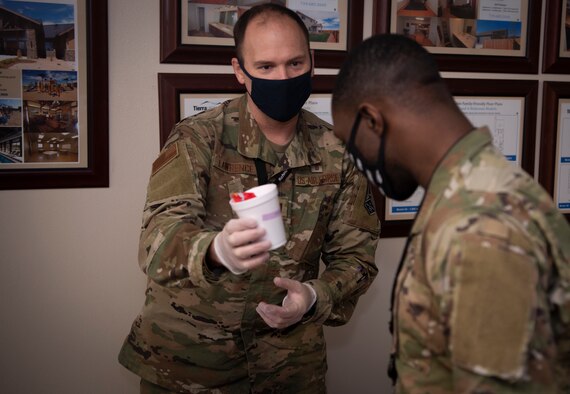 Capt. Ronald Lawrence, Schriever chaplain, gives candy to an Airman as part of a resilience event Oct. 29, 2020, at Schriever Air Force Base, Colorado. Each cup contained a question that Airmen had to answer before receiving candy (U.S. Space Force photo by Airman Ryan Prince)
