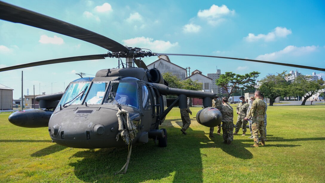 Medics listen to a safety brief concerning loading and unloading wounded patients into a UH-60 helicopter.
