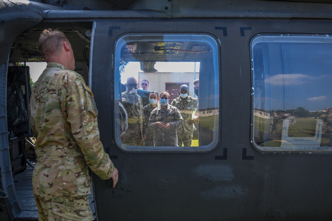 Medics listen to a safety brief concerning loading and unloading wounded patients into a UH-60 helicopter.