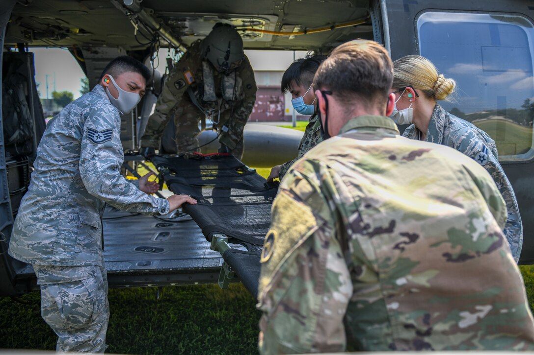 Medics load a gurney into a UH-60 helicopter