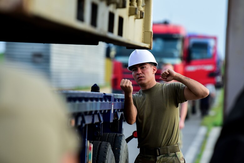Airman 1st Class Aaron Klawitter, 8th Maintenance Squadron management stockpile technician, signals a driver at Kunsan Air Base, Republic of Korea, Aug. 28, 2020. The 8th MXS and the Traffic Management Office transport unserviceable munitions back to the United States to be refurbished or destroyed twice a year. (U.S. Air Force photo by Senior Airman Jessica Blair)