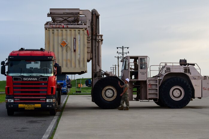 Senior Airman Tyler Attig, 8th Maintenance Squadron storage munitions technician, guides Staff Sgt. Brett Mohney, 8th MXS ammo flight munitions storage and handling technician, at Kunsan Air Base, Republic of Korea, Aug. 28, 2020. The International Organization for Standardization containers, or ISOs, are loaded onto Traffic Management Office trucks with an ISO loader that is able to lift up to 50,000 pounds. Containers of unserviceable munitions are shipped back to the United States twice a year and frees up crucial storage for resupply, increasing mission readiness capabilities of the 8th Fighter Wing. (U.S. Air Force photo by Senior Airman Jessica Blair)