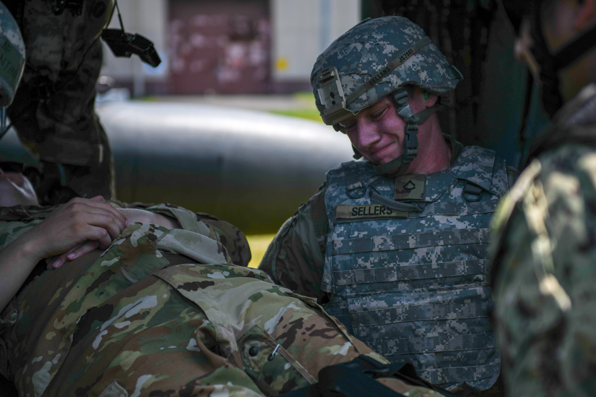 Private First Class Johnny Sellers, U.S. Aviation Battalion Japan 15T Black Hawk Crew Chief, lifts simulated patient into UH-60 helicopter.