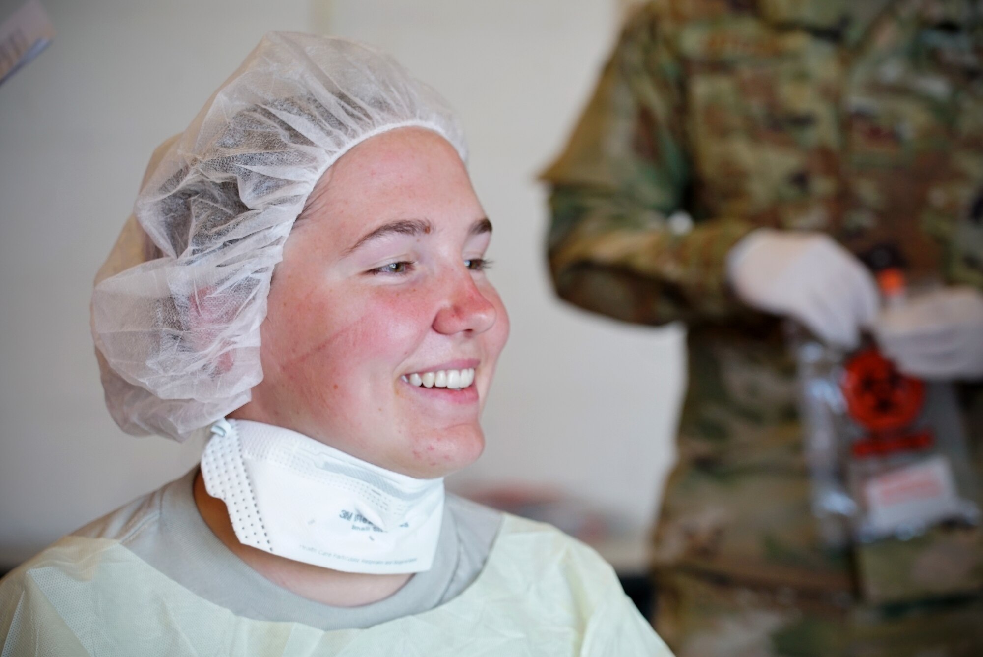 Portrait of a woman in personal protective gear smiling.