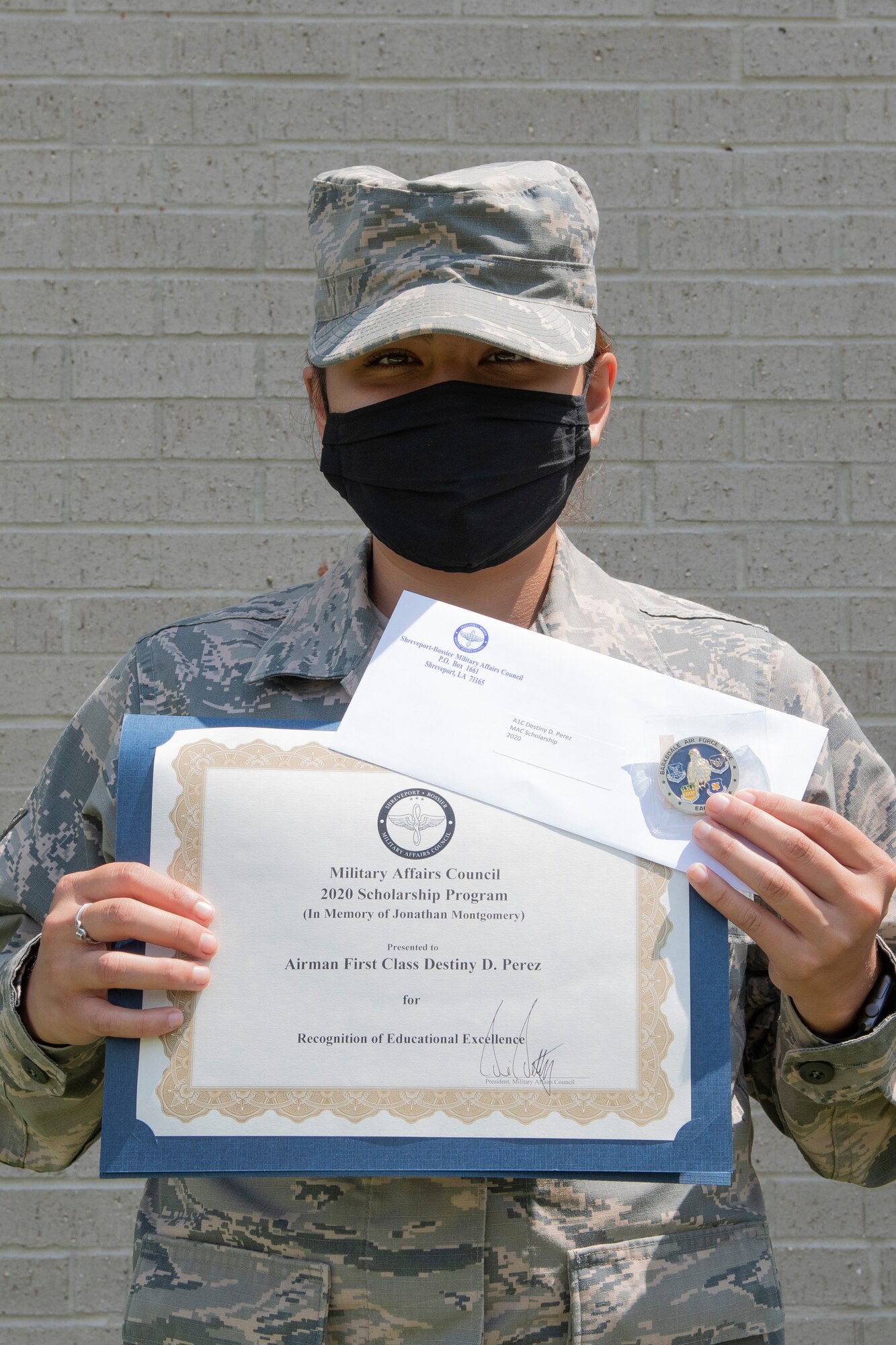 Photo of Airman posing with certificate.
