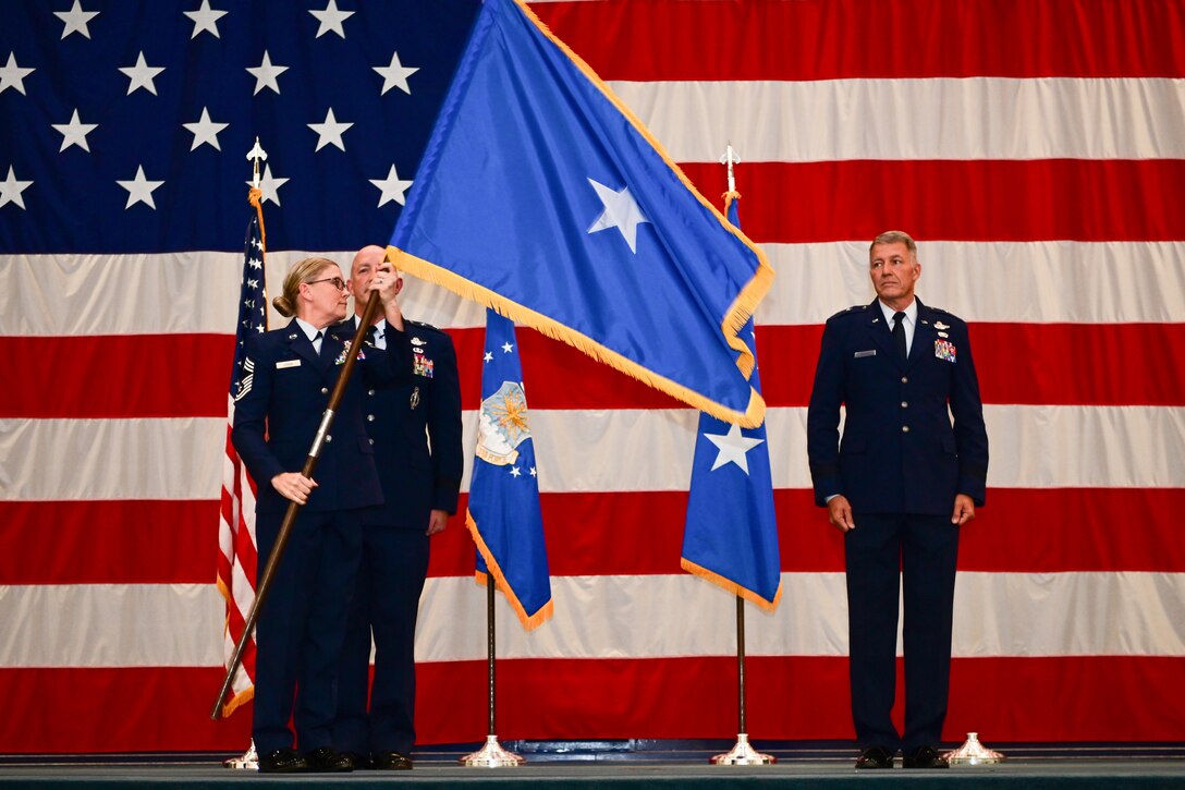 Photo of one-star general flag being unfurled on stage.