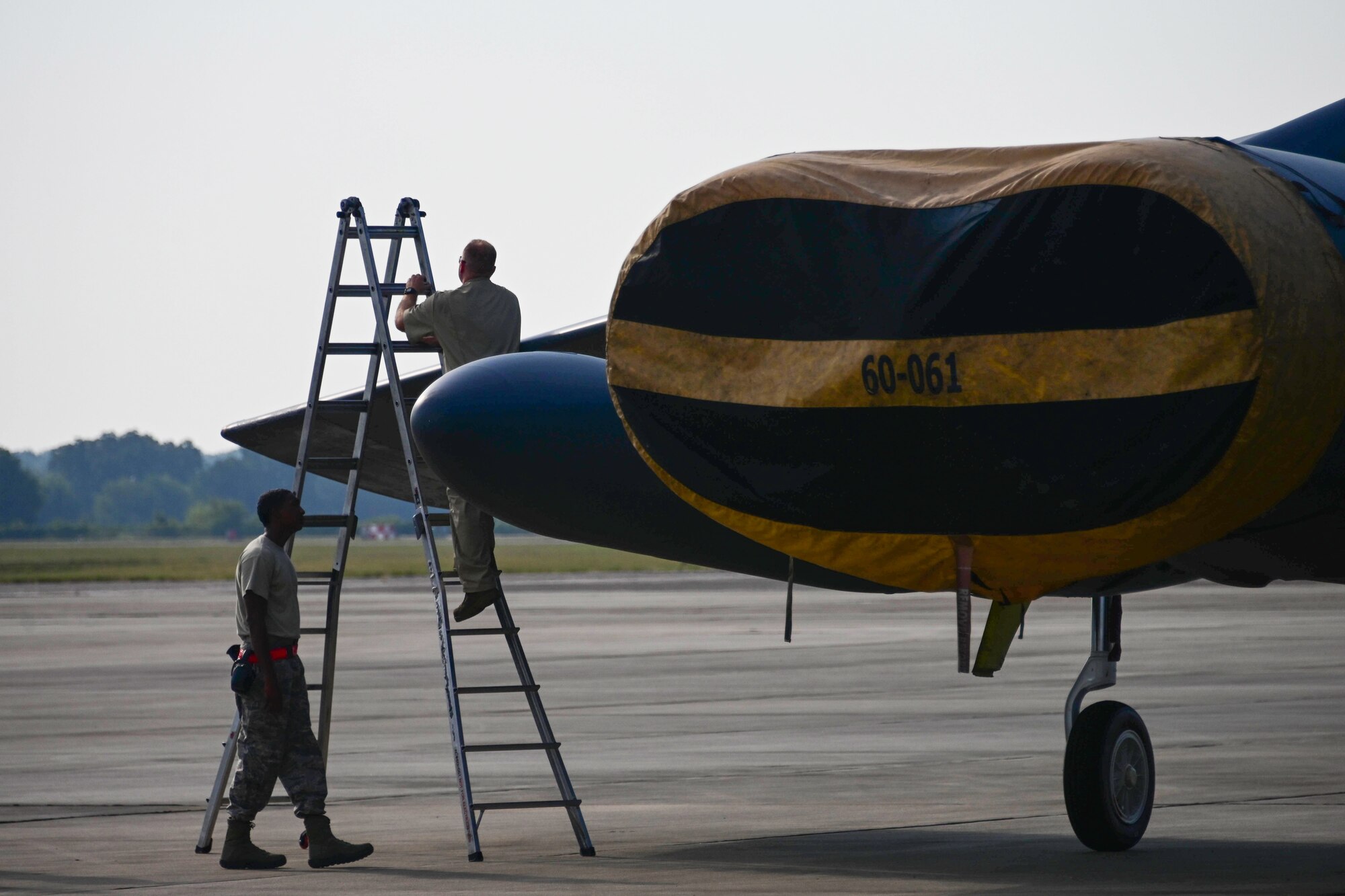 Photo of Airmen climbing ladder to work on B-52