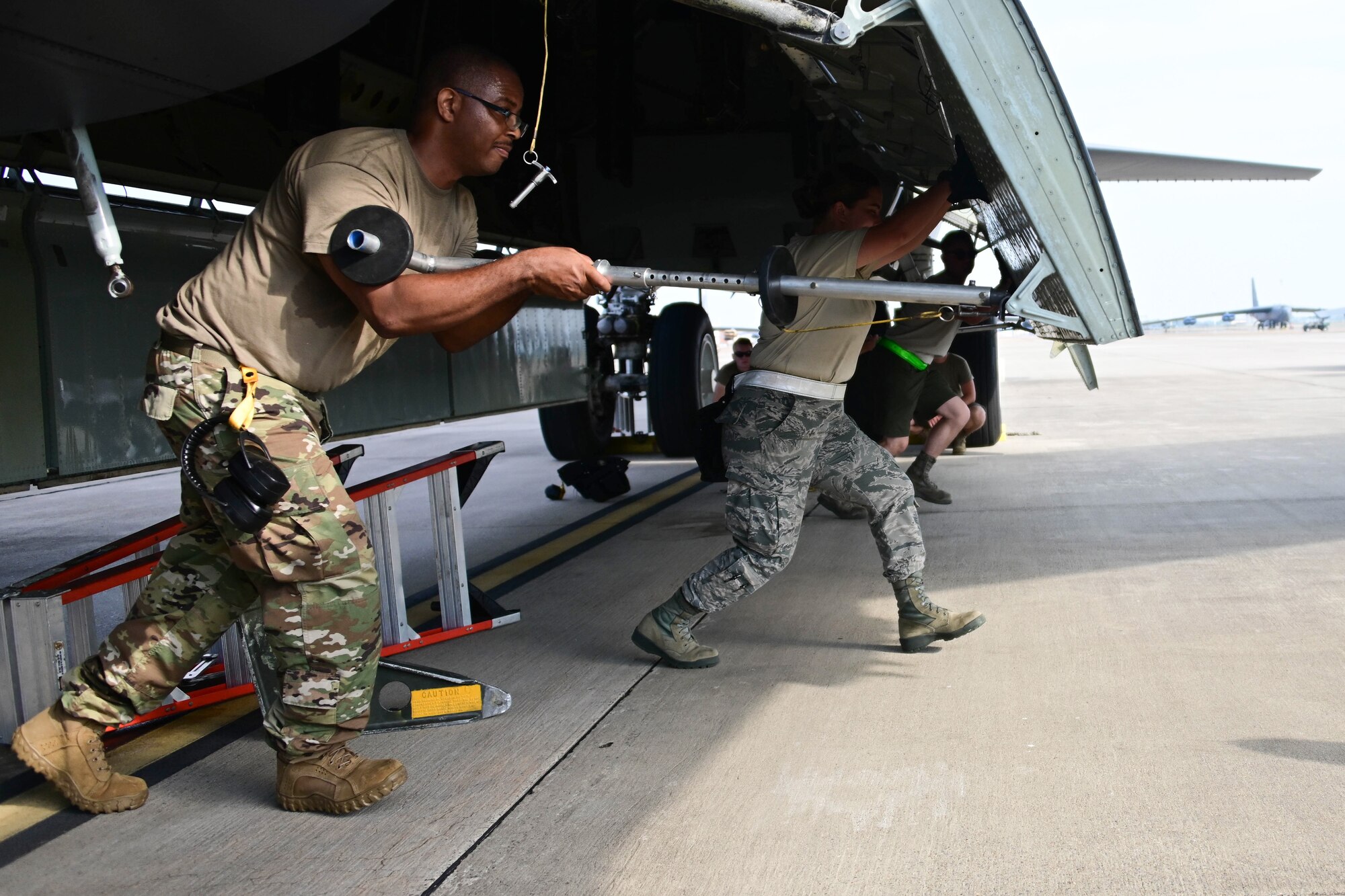 Photo of Airmen lined up and pushing open bomb bay door on a B-52.