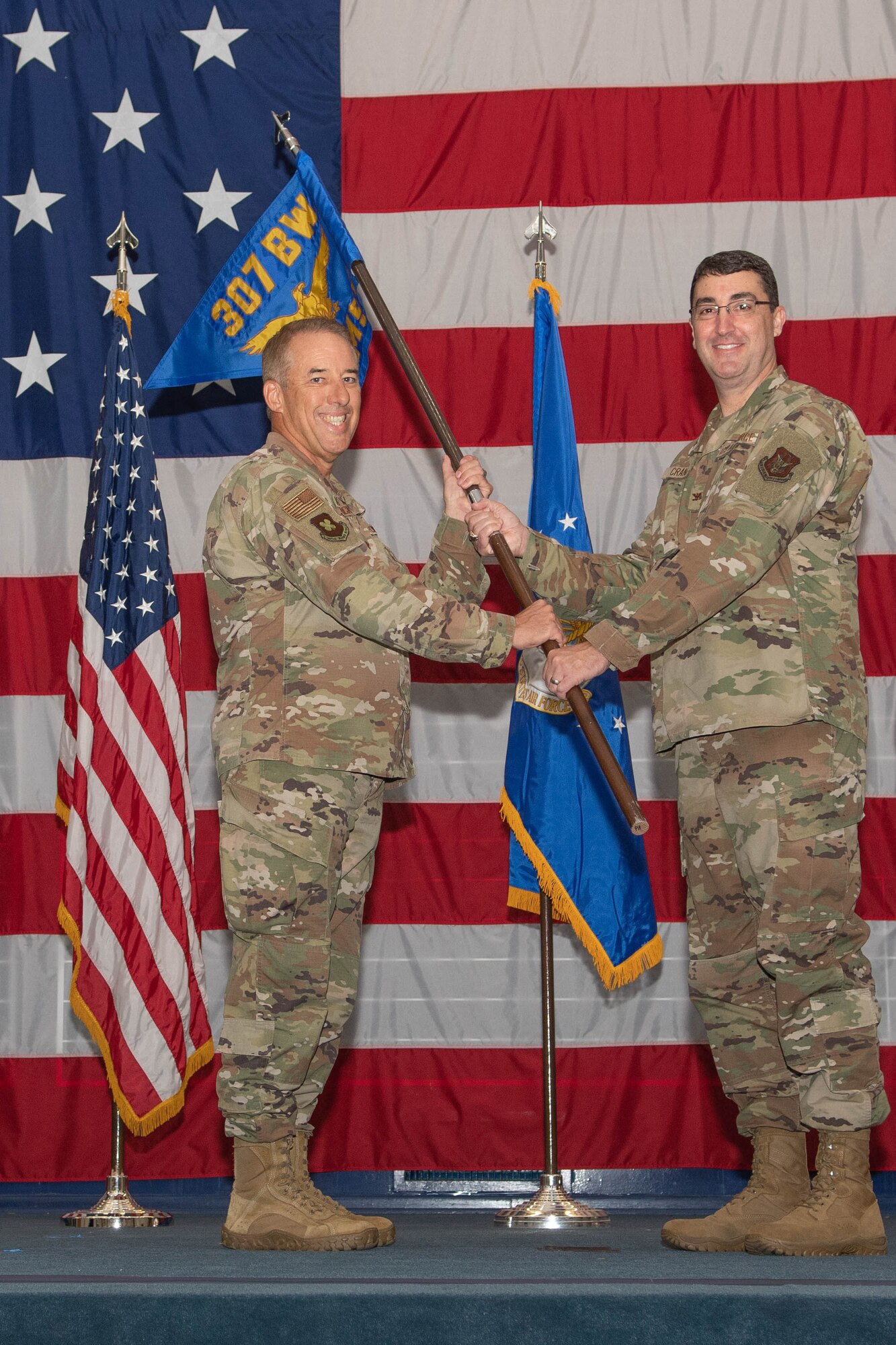 Photo of two Airmen exchanging 307th Maintenance Group guidon.