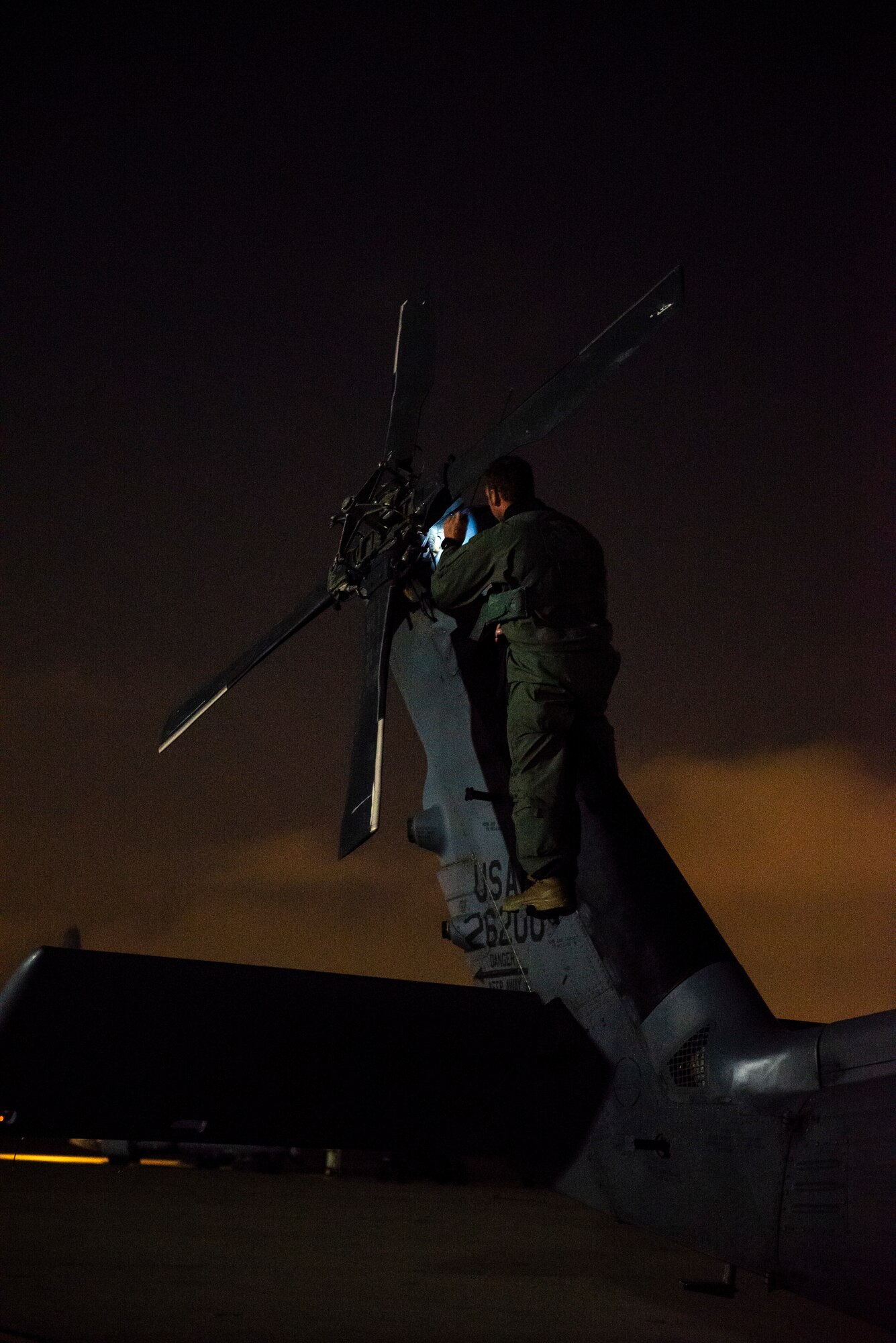 a photo of an airman on the tail of an HH-60