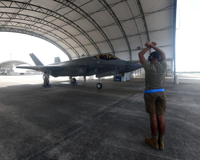 U.S. Air Force Airman 1st Class Jaivon Bland, 33rd Aircraft Maintenance squadron F-35A Lightning II dedicated crew chief, signals to the pilot during launch procedures at Eglin Air Force Base, Florida, Aug. 26, 2020. The 33rd AMXS introduced a shorts uniform to help combat hot weather conditions on the flightline. (U.S. Air Force photo by Airman 1st Class Amber Litteral)