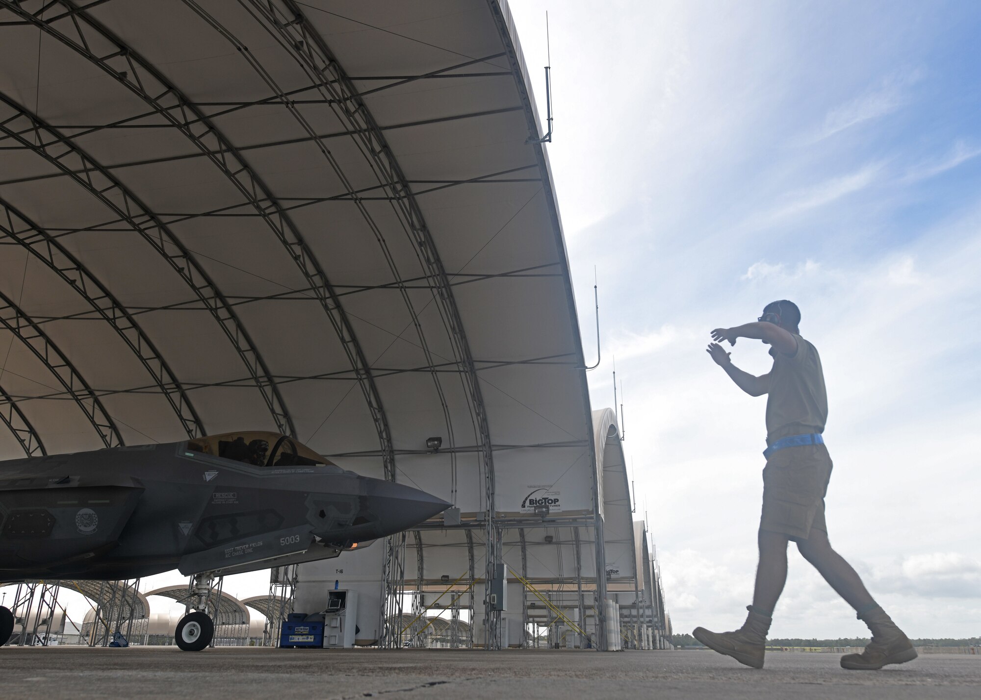 U.S. Air Force Airman 1st Class Jaivon Bland, 33rd Aircraft Maintenance squadron F-35A Lightning II dedicated crew chief, signals to the pilot during launch procedures at Eglin Air Force Base, Florida, Aug. 26, 2020. The 33rd AMXS introduced a shorts uniform to help combat hot weather conditions on the flightline. (U.S. Air Force photo by Airman 1st Class Amber Litteral)