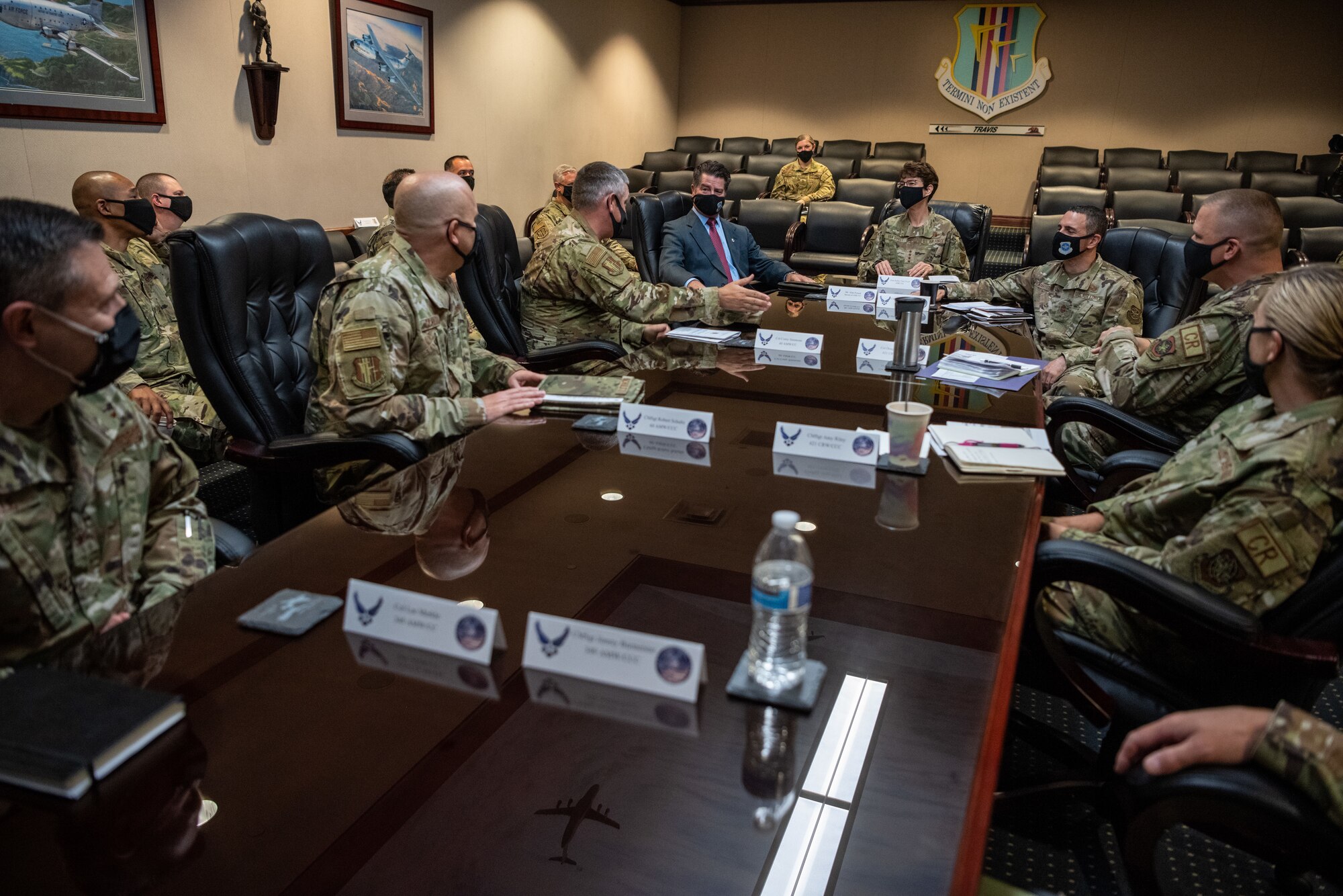 Military members sit in a conference room around a long table.