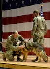 Tedy receives a meritorious service medal from the 354th Security Forces Squadron commander during the Military Working Dog's retirement ceremony.