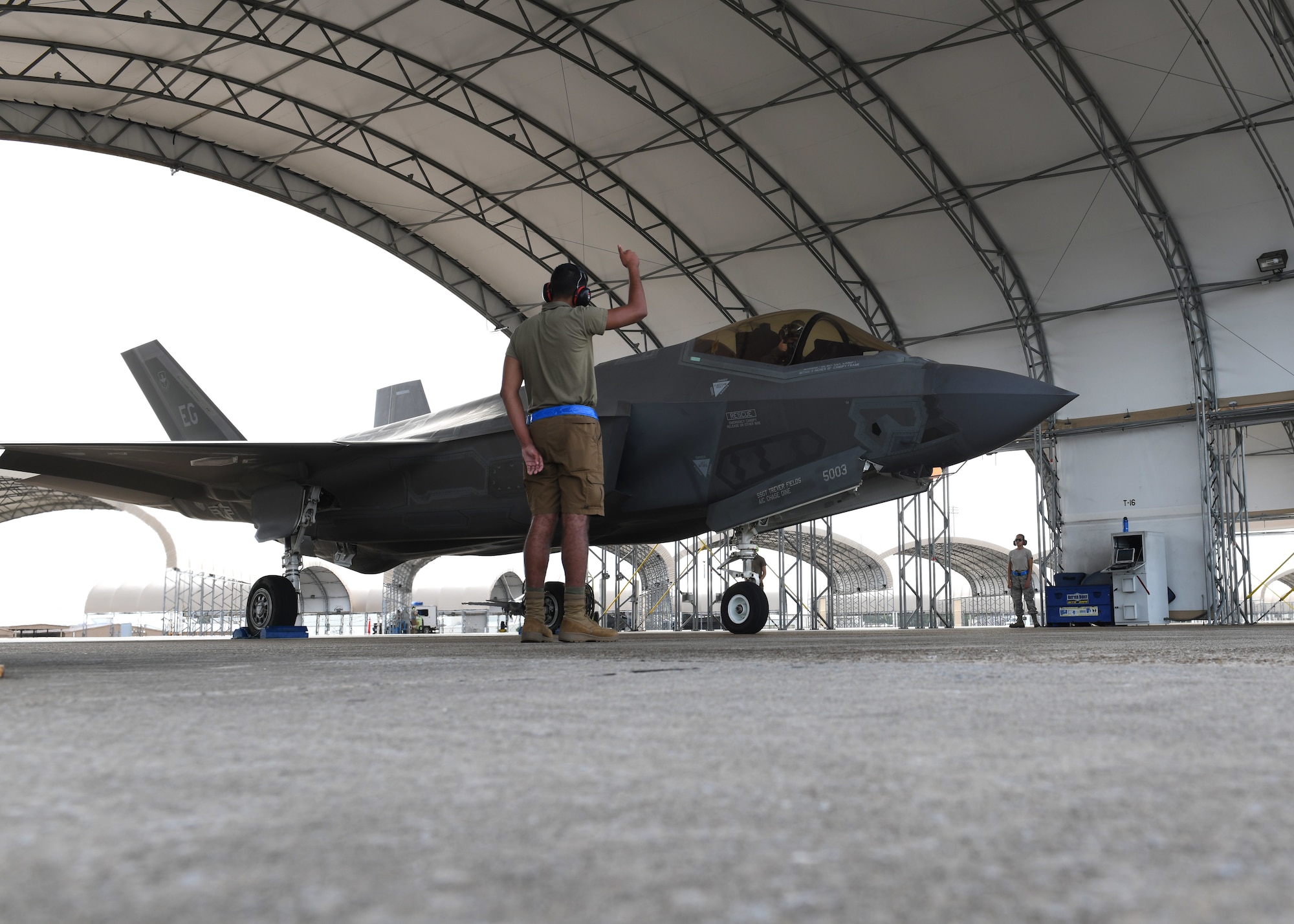 U.S. Air Force Airman 1st Class Jaivon Bland, 33rd Aircraft Maintenance squadron F-35A Lightning II dedicated crew chief, signals to the pilot during prelaunch procedures at Eglin Air Force Base, Florida, Aug. 26, 2020. The 33rd AMXS introduced a shorts uniform to help combat hot weather conditions on the flightline. (U.S. Air Force photo by Airman 1st Class Amber Litteral)