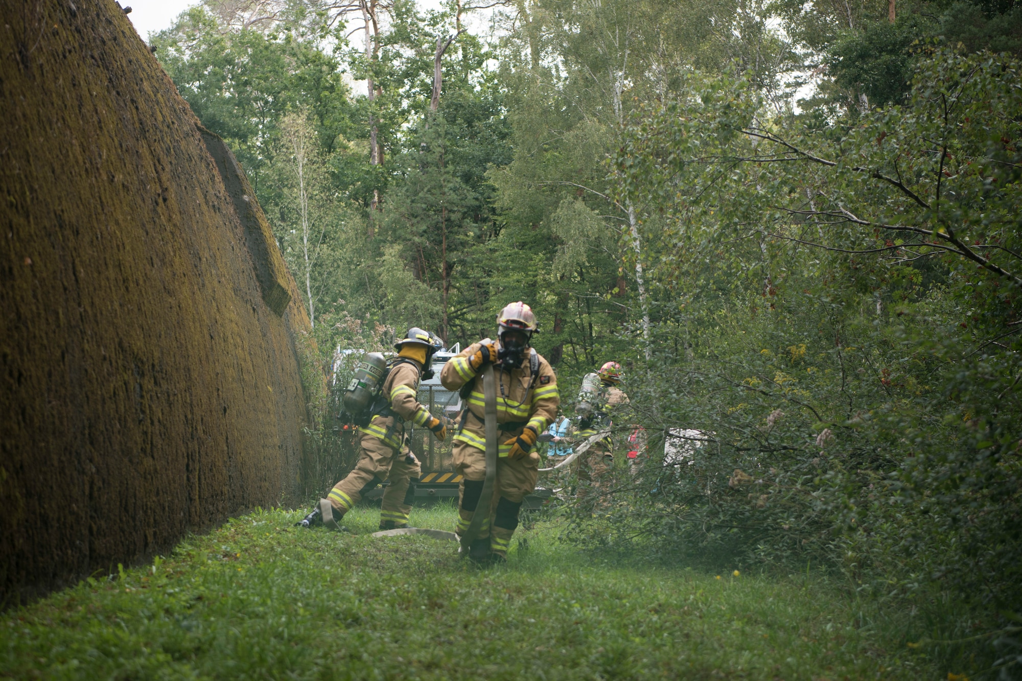 Firefighters run to the simulated aircraft crash site.