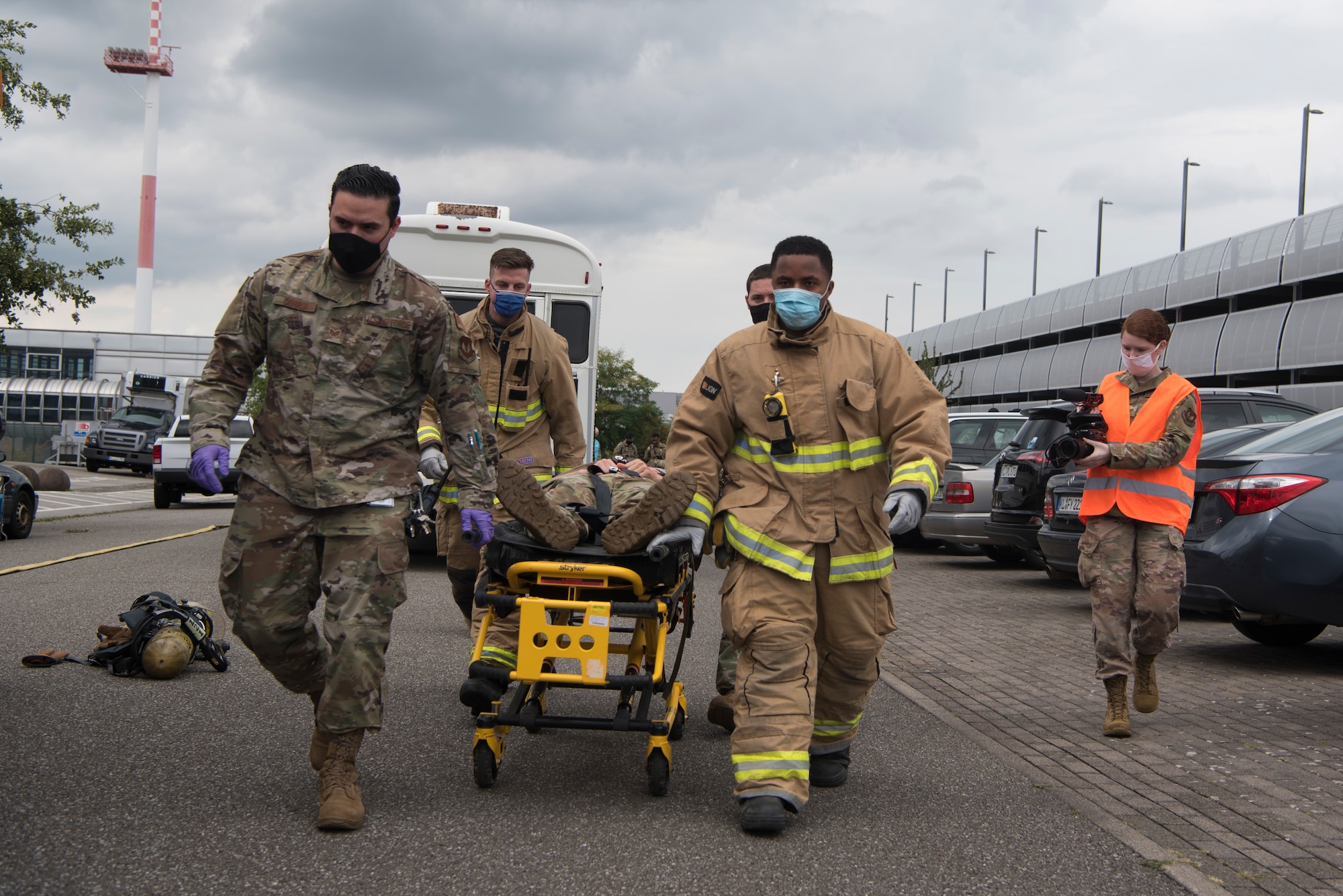 Airmen escort injured victim to ambulance.