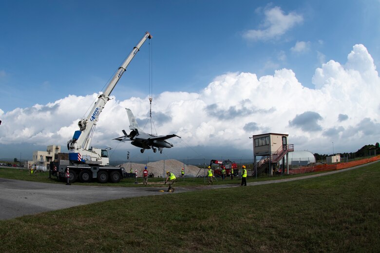 Airmen from the 31st Maintenance Squadron and 52nd MXS work together to relocate an F-16 Fighting Falcon during a training event at Aviano Air Base, Italy, Aug. 29, 2020.  The purpose of this training is to prepare Airmen to quickly remove an aircraft from the runway during a real world event. (U.S. Air Force photo by Senior Airman Caleb House)