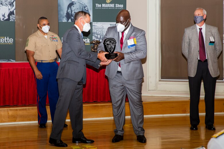 William Faulkner, center to left, President and CEO of Marine Corps Association and Foundation (MCA&F), presents the Civilian Staff Member of the Year award to David McIntyre, center to right, an administrative officer with Wounded Warrior Battalion-East, during the 10th annual Wounded Warrior Leadership Awards ceremony hosted by the MCA&F, at the Marston Pavilion on Marine Corps Base Camp Lejeune, North Carolina, Aug. 20, 2020. Six Marines and civilians with the Wounded Warrior Regiment were recognized by MCA&F for their professionalism, exceptional leadership and achievements. (U.S. Marine Corps photo by Lance Cpl. Christian Ayers)