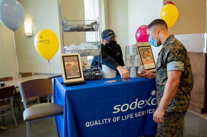 Allen Wolff, left, an information technology specialist for Sodexo, provides information on the newly released mobile app, Charge by Sodexo, to a U.S. Marine during the app’s launch event at the French Creek 65 Mess Hall on MCB Camp Lejeune, North Carolina, Aug. 24, 2020. Charge by Sodexo is a free mobile app available on the Google Play Store and Apple App Store and features mess hall searching capability through geo-location or installation name and mess hall number which allows users to view local menus for specialty bars, caloric intake information, nutrition facts and feedback.  (U.S. Marine Corps photo by Lance Cpl. Ginnie Lee)