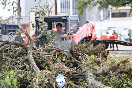 Louisiana National Guard Senior Airman William Bommer, 159th Civil Engineering Squadron’s heavy equipment journeyman,  removes tree branches in downtown Lake Charles, La., Aug. 30, 2020, after Hurricane Laura caused heavy damage in the area.