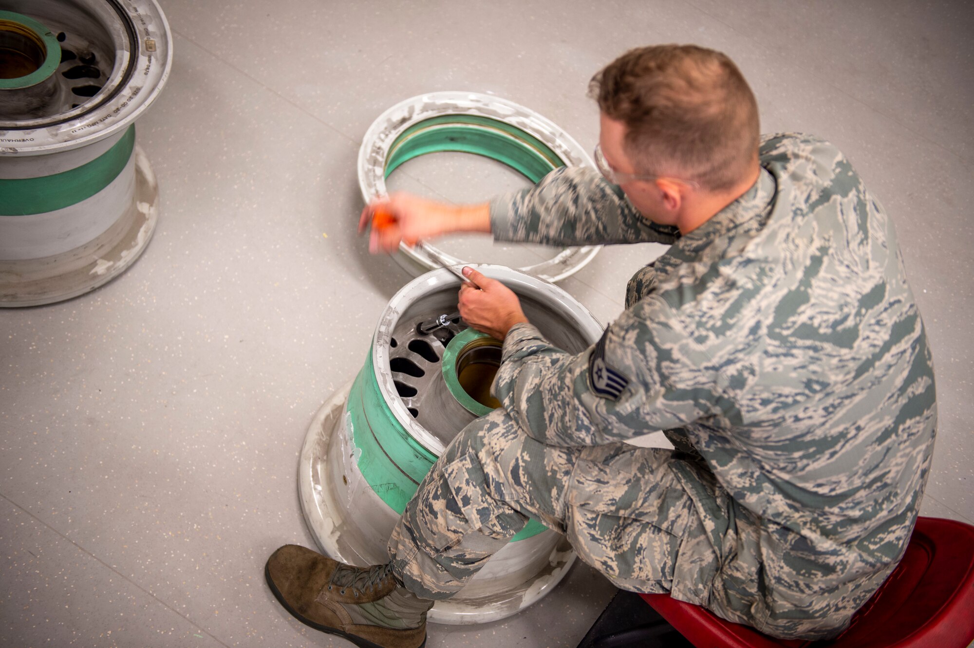 U.S. Air Force Staff Sgt. Logan Konigson, repair and reclamation specialist, 133rd Maintenance Squadron, disassembles a wheel assembly for refurbishment in St. Paul, Minn., Aug. 21, 2020.