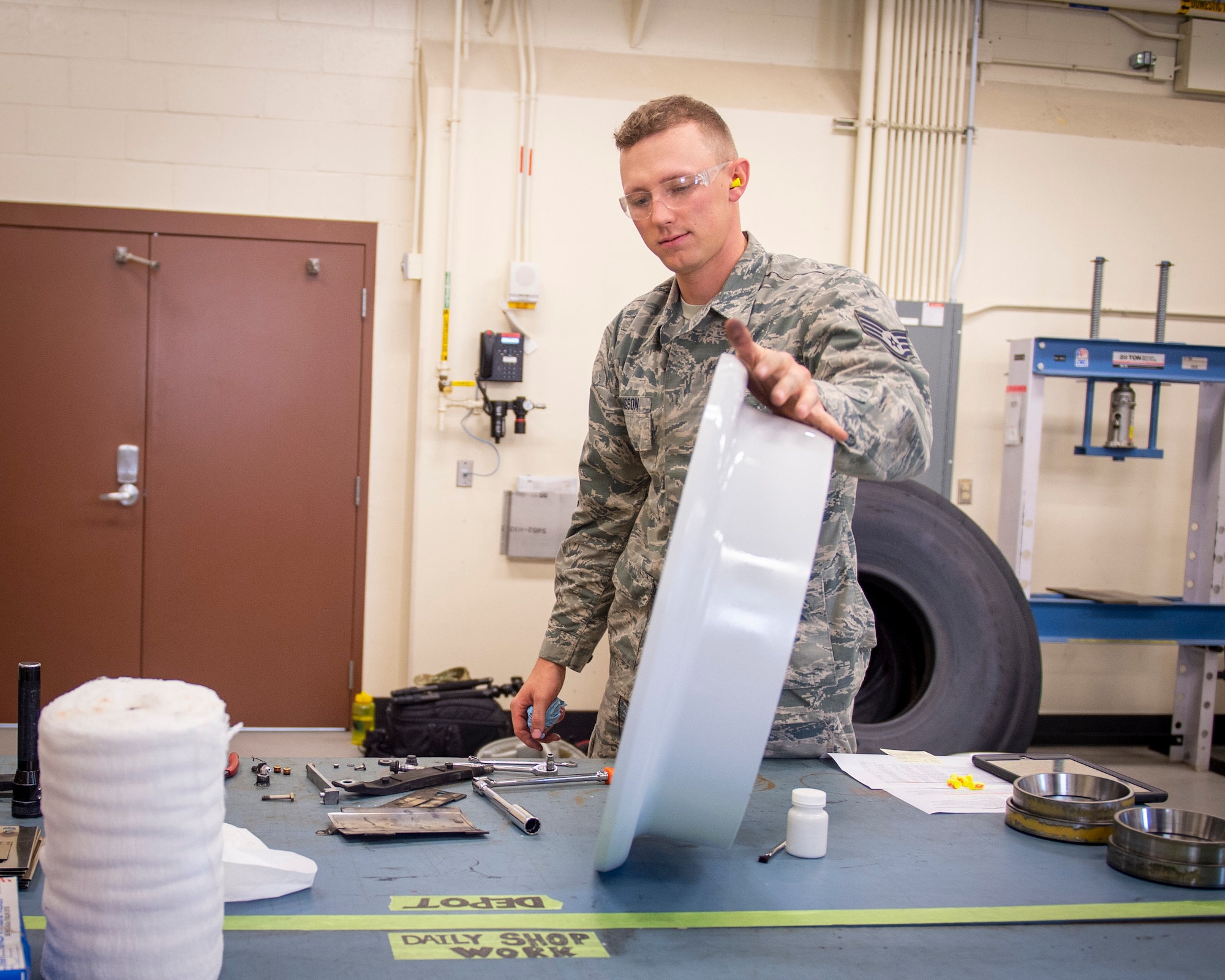 U.S. Air Force Staff Sgt. Logan Konigson, repair and reclamation specialist, 133rd Maintenance Squadron, disassembles a wheel assembly for refurbishment in St. Paul, Minn., Aug. 21, 2020.