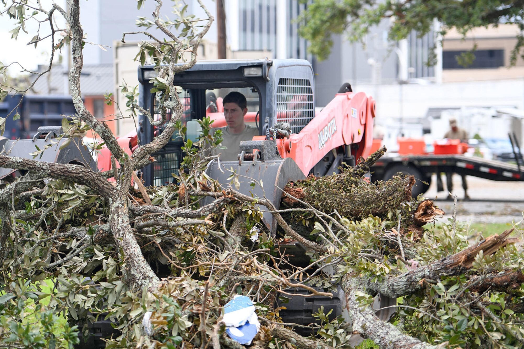 Louisiana National Guard Senior Airman William Bommer, 159th Civil Engineering Squadron’s heavy equipment journeyman,  removes tree branches in downtown Lake Charles, La., Aug. 30, 2020, after Hurricane Laura caused heavy damage in the area.