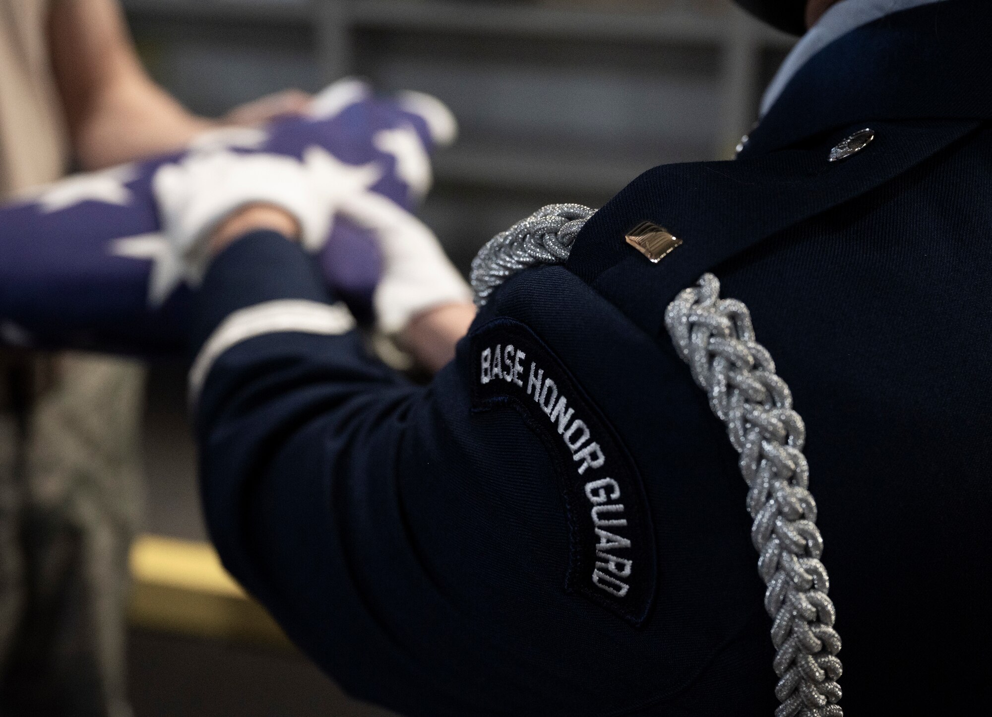 An Airman hands over the American flag