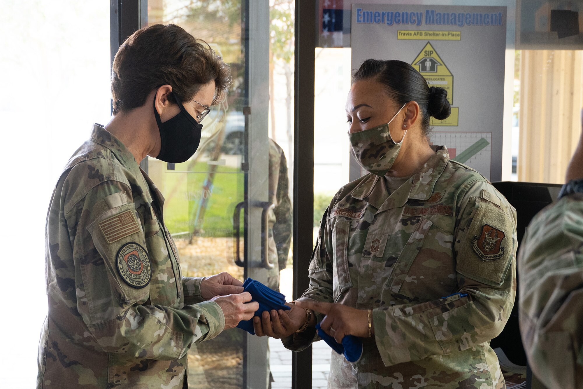 U.S. Air Force Senior Master Sgt. Lan Huong Archilla, right, 349th Security Forces Squadron first sergeant, presents an Air Force Reserve Command balaclava to Gen. Jacqueline D. Van Ovost, Air Mobility Command commander, during Van Ovost’s visit to the 349th Air Mobility Wing Headquarters, Travis Air Force Base, California, Sept. 1, 2020.