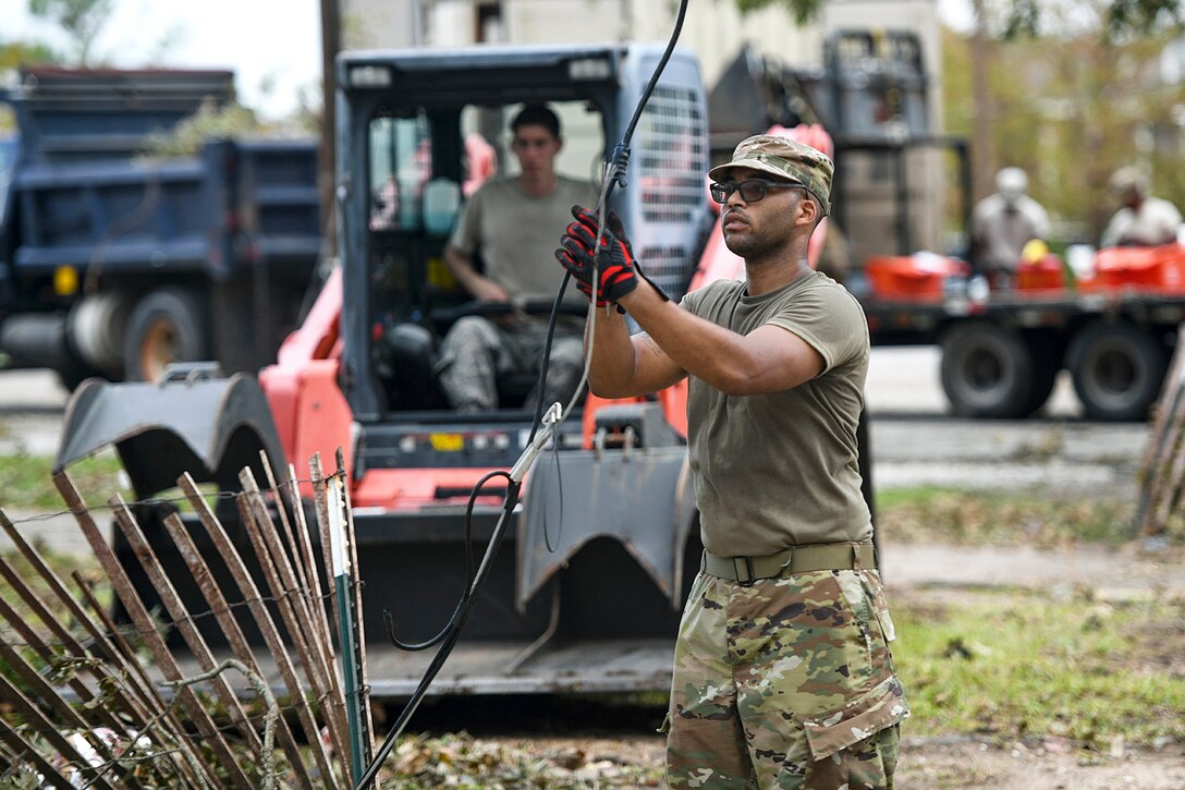 A National Guardsman holds a power line.