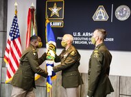 Col. Stephen Thomas passes the Army Acquisition Corps flag to Brig. Gen. Anthony Potts, signifying the relinquishing of his Project Manager responsibilities during the PM SSV change of charter at Fort Belvoir, Va., August 21, 2020.