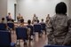 A female Airman stands as she asks the panelists a question