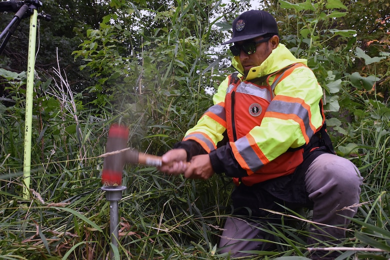 Man uses hammer to place survey monument