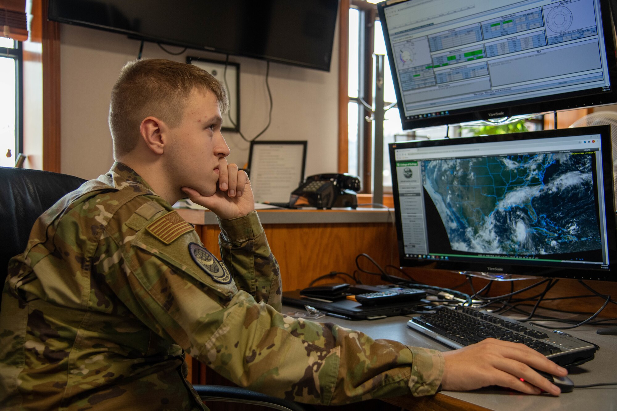 Man observes satellite weather patters on a monitor