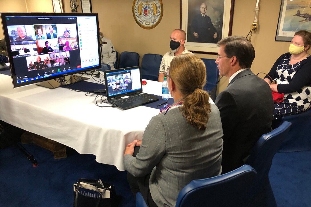 Two people speak to World War II veterans via a computer.