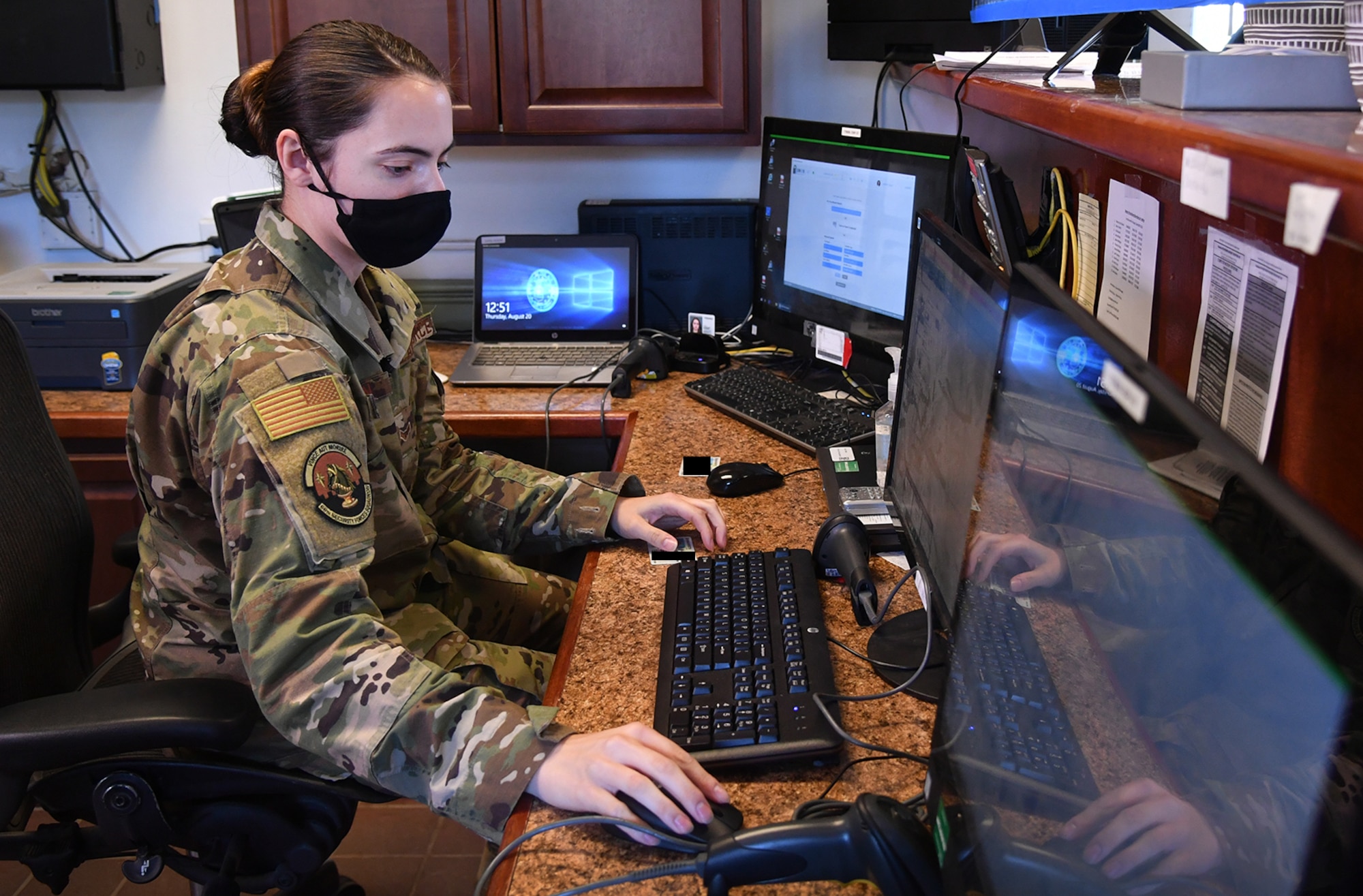 Airman 1st Class Ceara Larson, 66th Security Forces Squadron entry controller, checks a visitor’s identification with Bouncer Bot at the Visitor Control Center at Hanscom Air Force Base, Mass., Aug. 20. Bouncer Bot, a remote process automation software application, can check base visitors’ credentials against national crime databases in a matter of seconds. (U.S. Air Force photo by Linda LaBonte Britt)