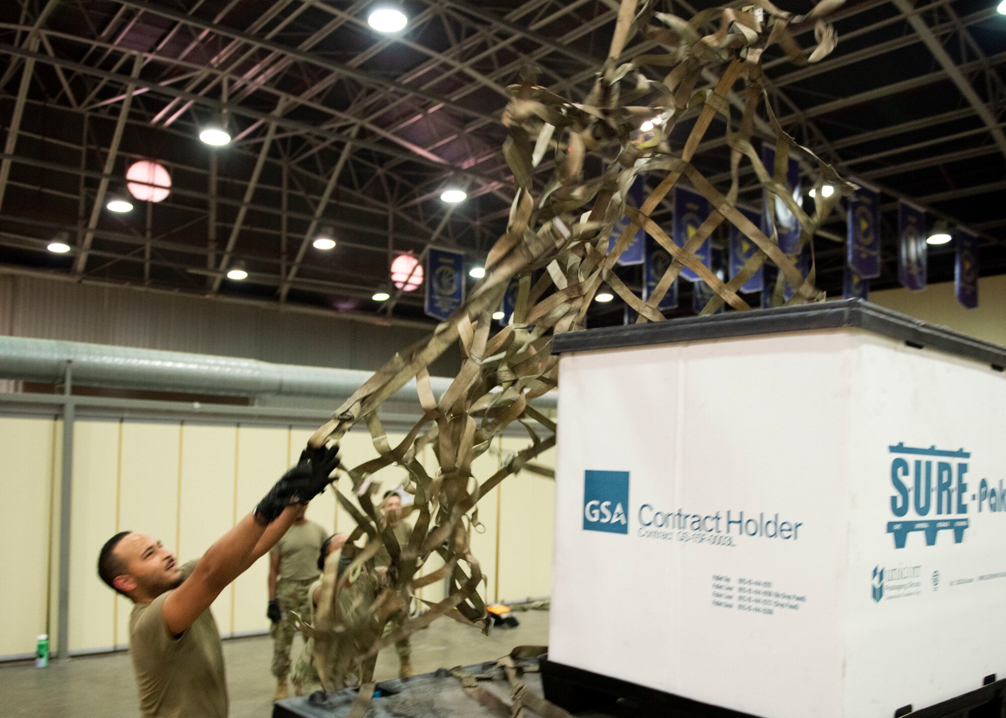 Airmen toss a cargo net over a loaded aircraft cargo pallet at interlink Air Base, Turkey.