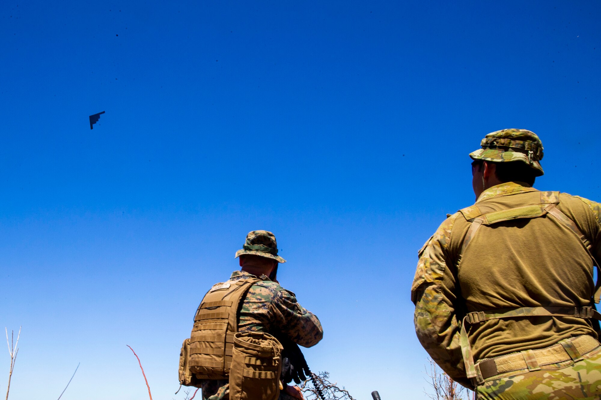 U.S. Marine Corps Capt. Benjamin Hovies with Command Element, Marine Rotational Force – Darwin, and Australian Army Sgt. Aaron Costas direct the flight path of a U.S. Air Force B-2 Spirit Bomber at Mount Bundey Training Area, Northern Territory, Australia, Aug. 24, 2020. Hovies is a native of Lebanon, Tenn. and Costas is a native of Imbil, Queensland. Within the training scenario, a combined team of U.S. Marines and Australian Defence Forces provided target information to U.S. Air Force bombers conducting deep strikes on notional targets. (U.S. Marine Corps photo by Cpl. Harrison Rakhshani)