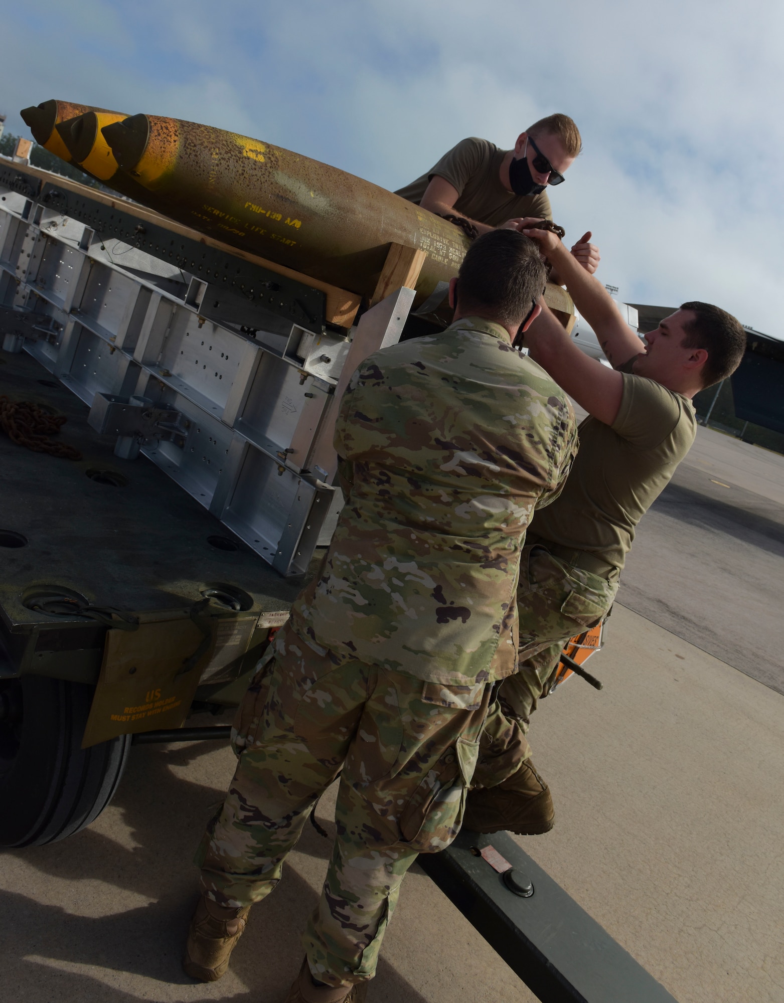 U.S. Air Force Airman 1st Class William Farrell (left), Staff Sgt. James Herrmann and Senior Airman Eric Henry, 393rd Expeditionary Bomb Squadron weapons load crew members, Whiteman Air Force Base, Missouri, load live weapons for B-2 Spirit Stealth Bomber training at Naval Support Facility Diego Garcia, to support a Bomber Task Force mission, Aug. 13, 2020. They, along with three B-2 Spirits deployed as part of a BTF.  As part of their BTF deployment, the B-2s participated in a combined United States-Australia exercise with Marine Rotational Force – Darwin and Australian Defence Forces. (U.S. Air Force photo by Senior Airman Alexandria Lee)
