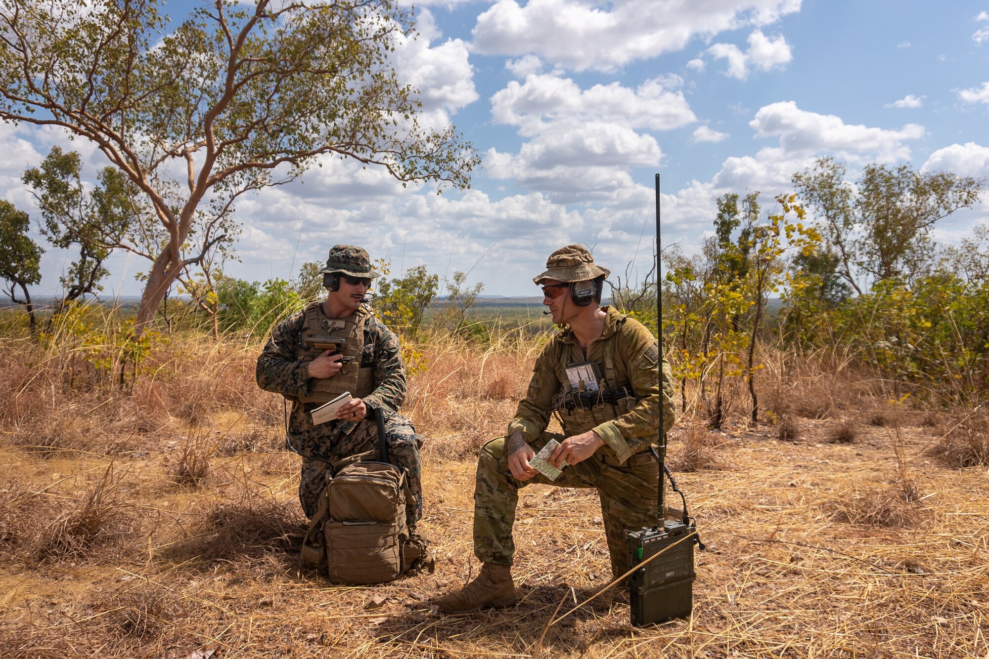 U.S. Marine Corps Staff Sgt. Micheal Mendoza, a joint terminal attack controller with Command Element, Marine Rotational Force - Darwin, left, and Australian Defence Force Sgt. Aaron Costas, with 102nd Coral Battery, communicate to a B-1B Lancer pilot at Mount Bundey Training Area, Northern Territory, Australia, Aug. 14, 2020. The combined training allowed both Marines and Australian Defence Force members to learn how to communicate effectively to be ready to work together to to contribute to regional security. (U.S. Marine Corps photo by Cpl. Sarah Marshall)