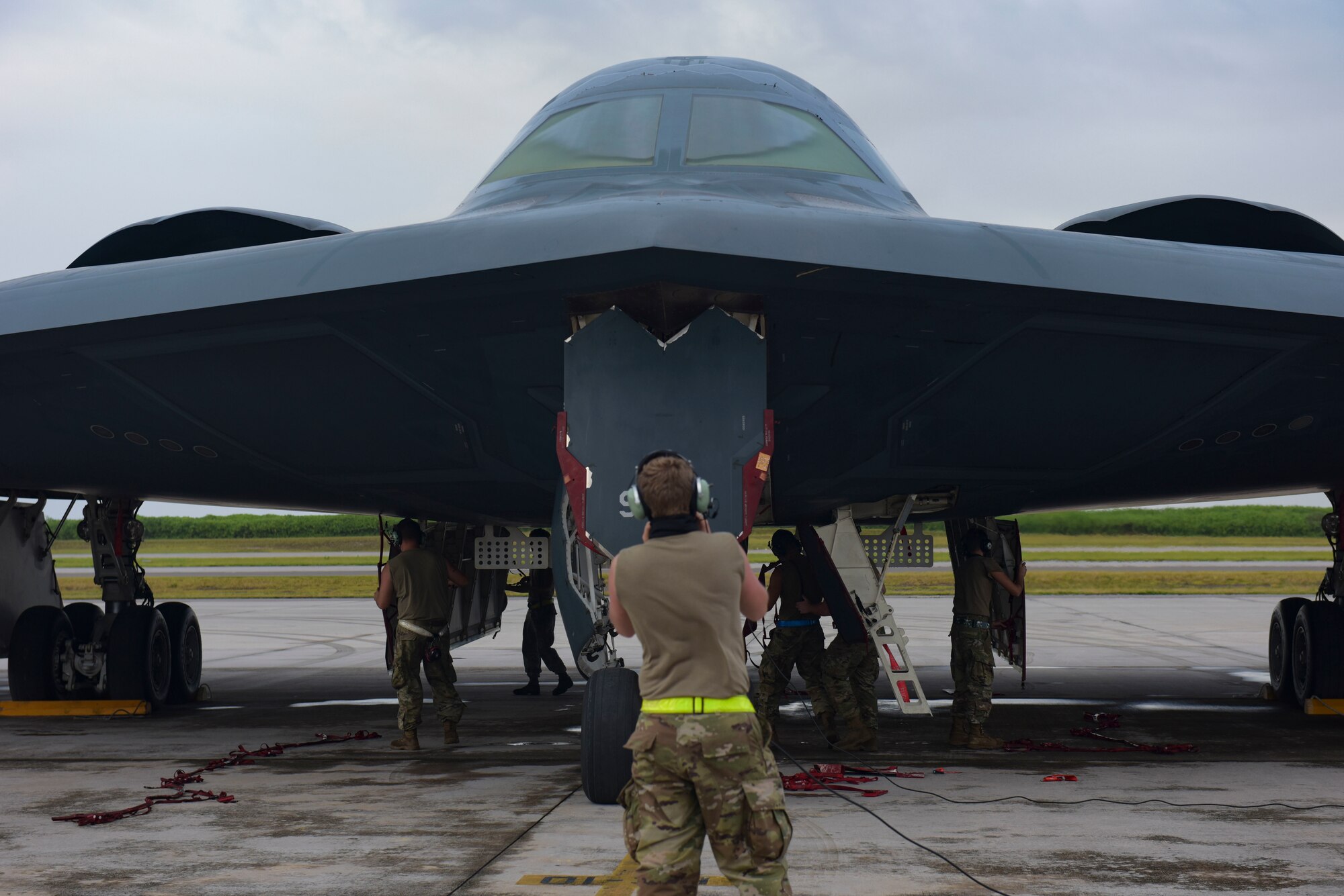 A U.S. Air Force maintainer assigned to the 393rd Expeditionary Bomb Squadron, Whiteman Air Force Base, Missouri, talks to the pilots of a B-2 Spirit Stealth Bomber at Naval Support Facility Diego Garcia, to support a Bomber Task Force mission, Aug. 14, 2020. As part of their BTF deployment, the B-2s participated in a combined United States-Australia exercise with Marine Rotational Force -Darwin and Australian Defence Forces. During the exercise, MRF-D and ADF Joint Terminal Attack Controllers coordinated airstrikes with U.S. Air Force B-1B Lancers and B-2 Spirit Stealth Bombers. (U.S. Air Force photo by Senior Airman Alexandria Lee)