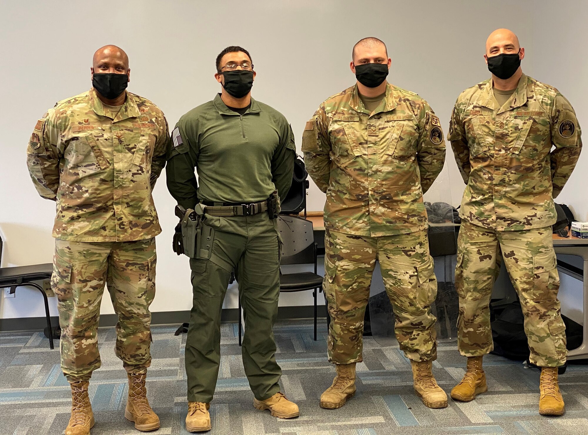 From left to right, Col. Devin Pepper, Buckley Garrison Commander, Senior Airman Tyler Banks, 460th Security Forces Squadron Base Defense Operations Center controller, Senior Airman Trey Flowers, 460th SFS Restricted Area controller, and Chief Master Sgt. Robert Devall, Buckley Garrison command chief, pose for a photo at the 460th SFS training site at Buckley Air Force Base, Colo. Banks and Flowers were both coined by Pepper for their outstanding performance during the COVID-19 pandemic and local protests. (Courtesy photo)
