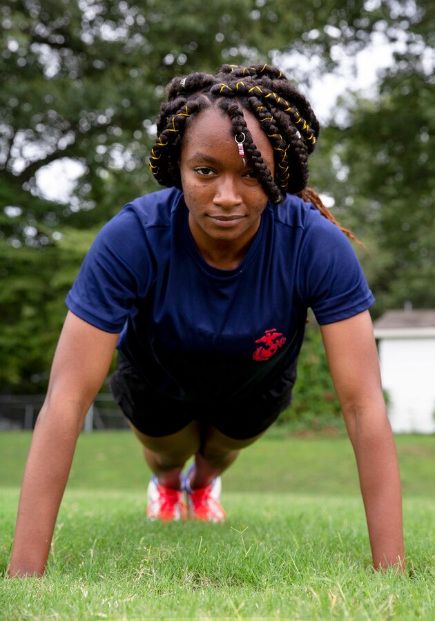 Alexia Fields, center, a poolee with Permanent Contact Station (PCS) Dyersburg, performs push-ups during a physical training session with the poolees of PCS Dyersburg, Recruiting Substation Jackson, Recruiting Station Nashville at Dyersburg High School, Dyersburg, Tennessee, Aug. 27, 2020.  Poolees participate in physical training sessions with the recruiters to ensure they are physically prepared to endure the challenges of Marine Corps recruit training. Alexia and her older brother Jaquan, back-right, both poolees with PCS Dyersburg, have overcome personal adversity resulting in growth and gained confidence, which further solidified their decisions to join the Marine Corps Delayed Entry Program.