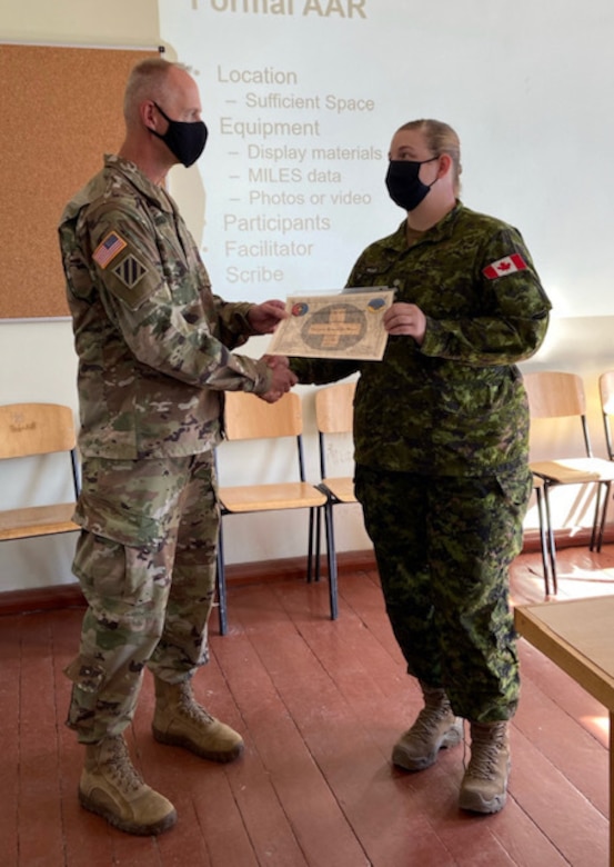 Canadian Forces Capt. Samantha Wall is presented with a certificate of appreciation from Col. Glen Petersen, Deputy Commander of Task Force Illini, Aug. 28 at Combat Training Center-Yavoriv, Ukraine.