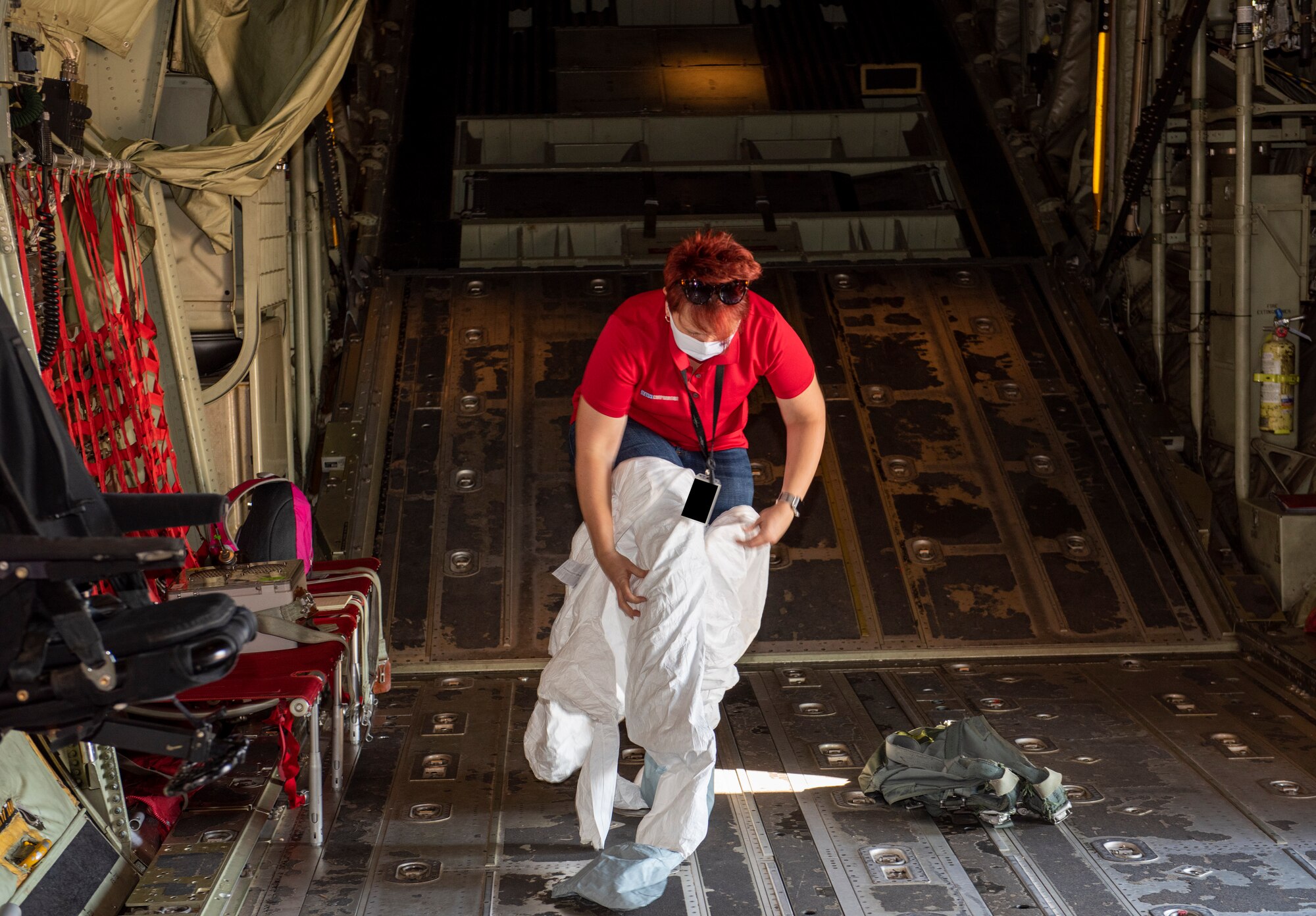 Michelle Docter, 711th Human Performance Wing research chemist from Wright-Patterson Air Force Base, Ohio, puts on a disposable suit inside of a C-130J Super Hercules aircraft at Dyess AFB, Texas, Aug. 26, 2020.