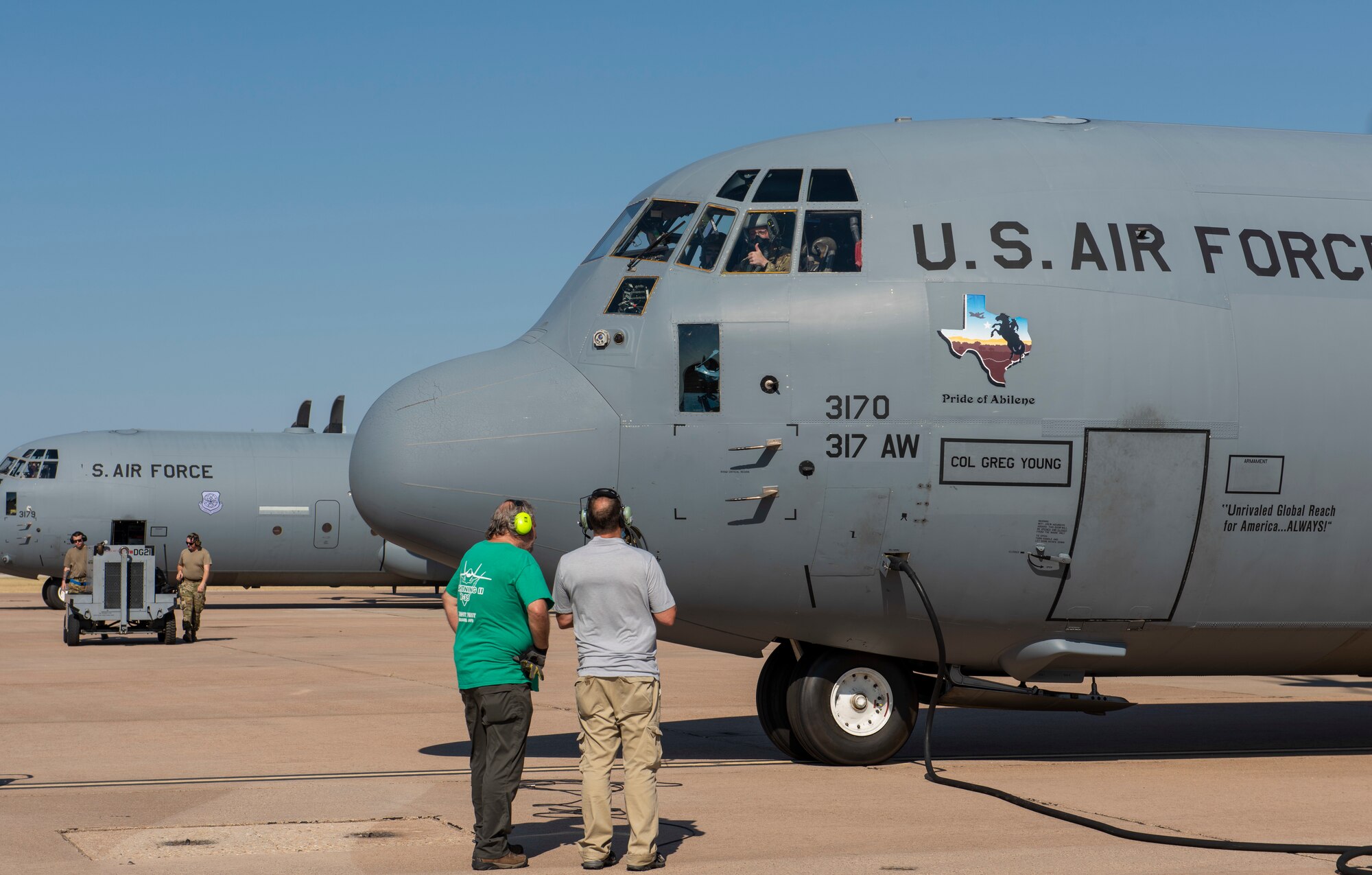 A C-130J Super Hercules pilot, assigned to the 317th Airlift Wing, gives a thumbs up to two research scientists, assigned to the 711th Human Performance Wing from Wright-Patterson Air Force Base, Ohio, on the flightline at Dyess AFB, Texas, Aug. 26, 2020.