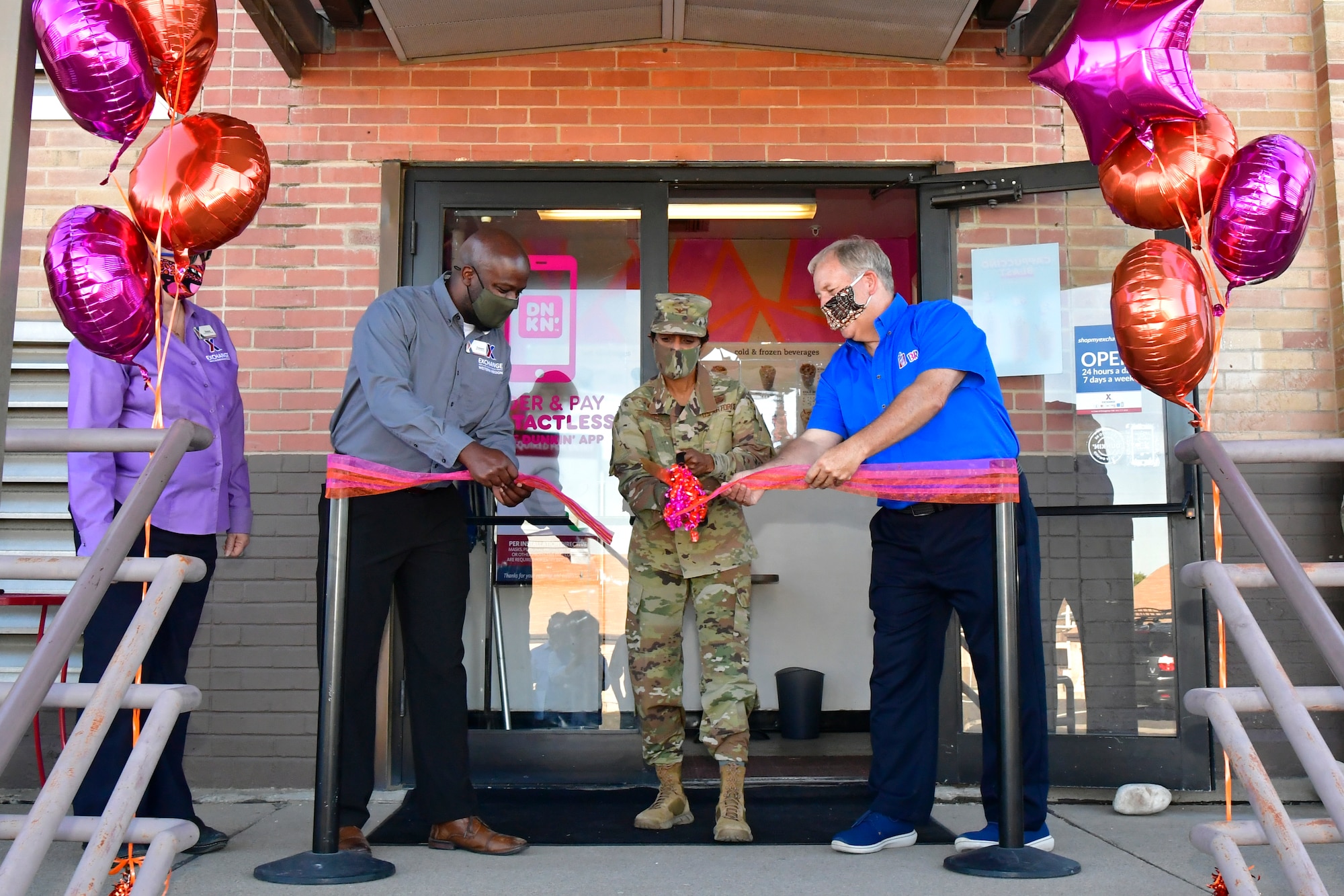 (Left to right) Edward James, Hill Exchange acting general manager, Col. Jenise Carroll, 75th Air Base Wing commander, and George Hart, Dunkin’ and Baskin-Robbins franchisee, cut the ribbon in front of Dunkin’ Donuts and Baskin-Robbins.