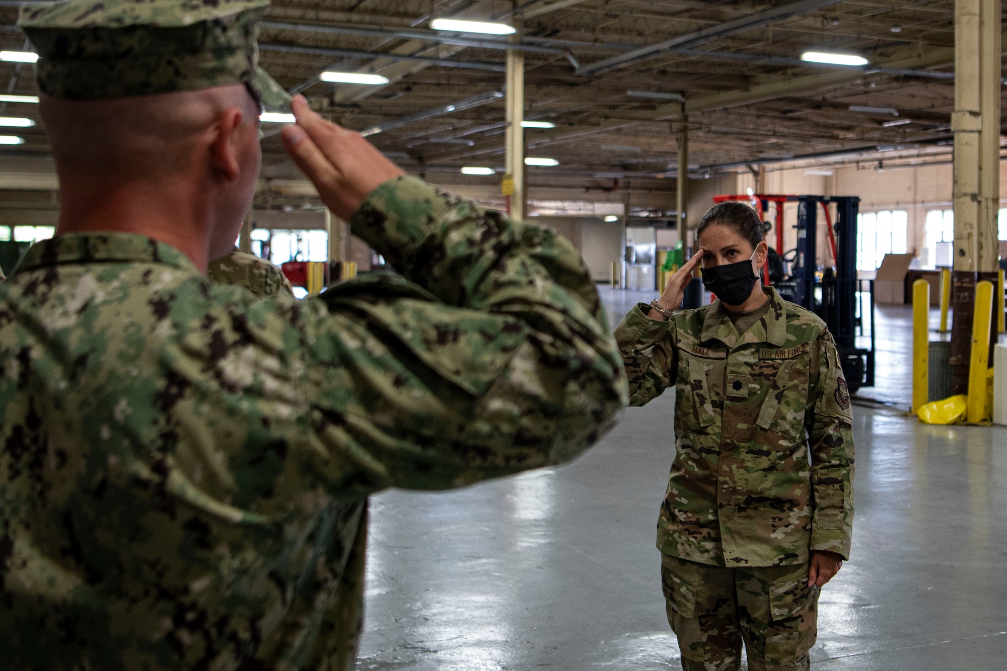 Photo of an Airman saluting a sailor.