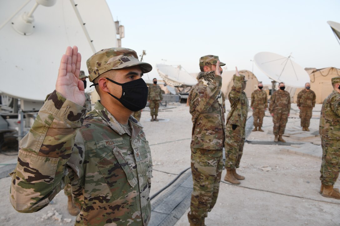 Airmen deployed to Al Udeid Air Base, Qatar, raise their right hands during an enlistment ceremony as they transferred into the Space Force on Sept. 1, 2020. The Space Force is the United States' newest service in more than 70 years. (U.S. Air Force photo by Staff Sgt. Kayla White)